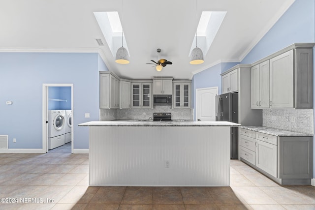 kitchen featuring appliances with stainless steel finishes, lofted ceiling with skylight, independent washer and dryer, and gray cabinetry