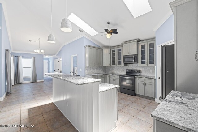 kitchen with lofted ceiling with skylight, ceiling fan with notable chandelier, black electric range, pendant lighting, and decorative backsplash