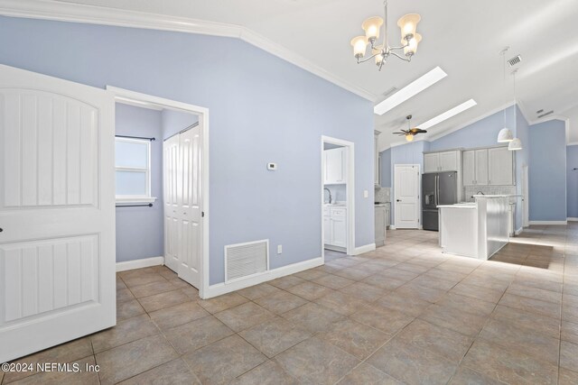 interior space featuring vaulted ceiling, ceiling fan with notable chandelier, crown molding, sink, and light tile patterned flooring