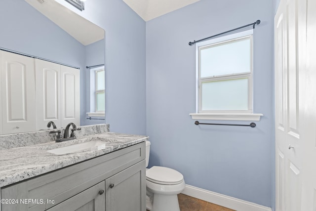 bathroom featuring toilet, tile patterned floors, baseboards, and vanity