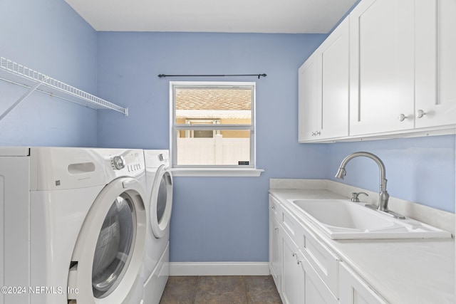 washroom featuring washer and dryer, cabinet space, a sink, and baseboards