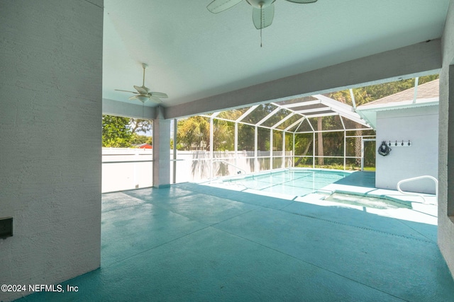 view of swimming pool with glass enclosure, a patio, and ceiling fan