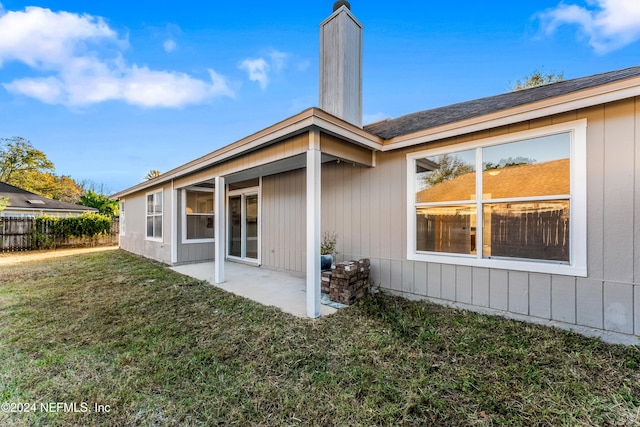 rear view of property featuring a patio area and a yard