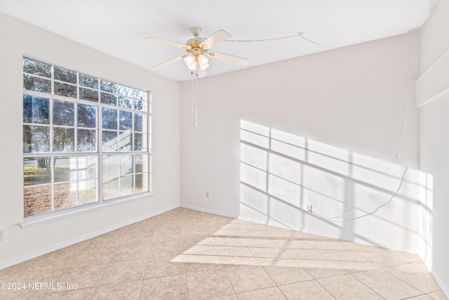 tiled empty room featuring ceiling fan