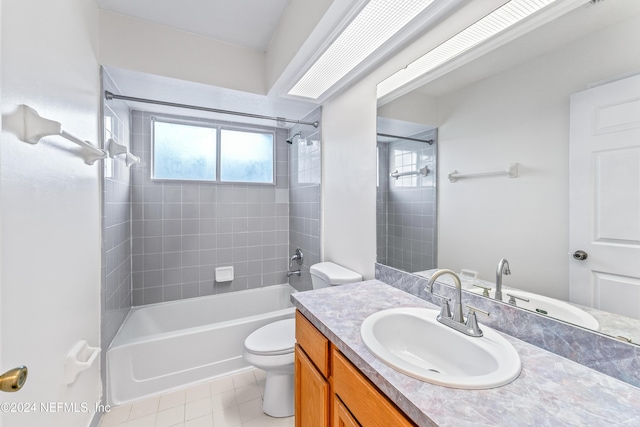 full bathroom featuring tile patterned floors, vanity, toilet, and tiled shower / bath