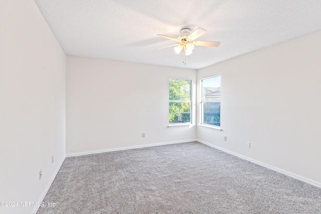 carpeted spare room with a textured ceiling and ceiling fan