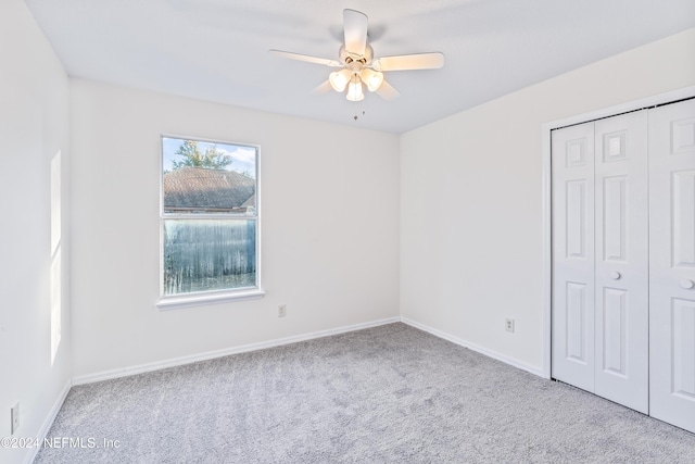 unfurnished bedroom with ceiling fan, a closet, and light colored carpet