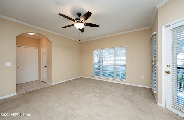 carpeted empty room with ceiling fan, ornamental molding, and a wealth of natural light