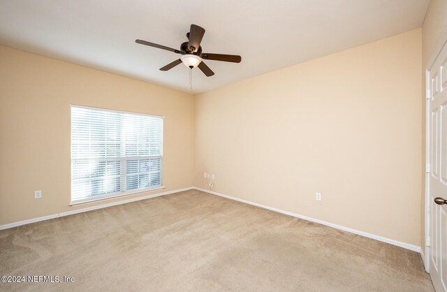 carpeted spare room with ceiling fan