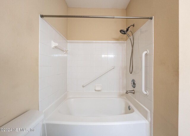 bathroom featuring tiled shower / bath and toilet