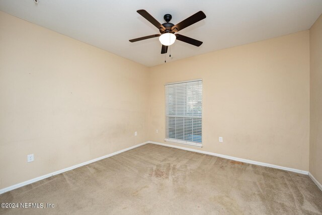 unfurnished room with ceiling fan and light carpet