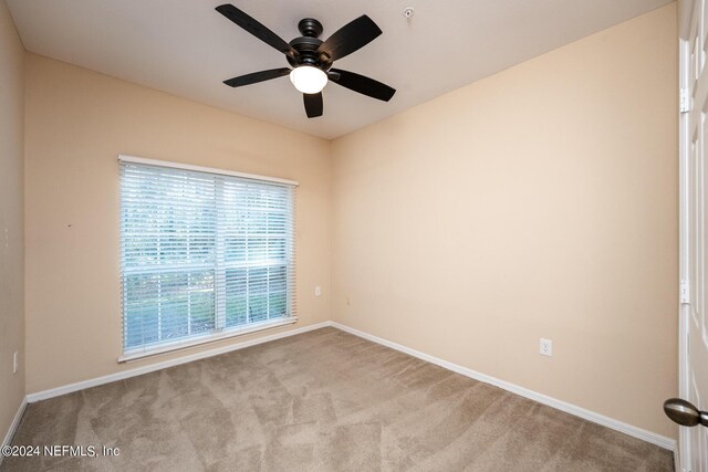 carpeted spare room featuring ceiling fan