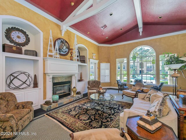 living room featuring high vaulted ceiling, ornamental molding, beam ceiling, a textured ceiling, and a premium fireplace