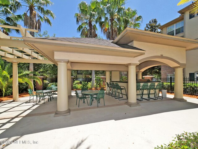 view of property's community featuring a patio, a pergola, and exterior bar