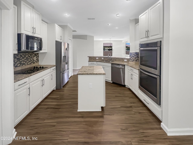 kitchen featuring light stone counters, a center island, white cabinetry, a peninsula, and black appliances