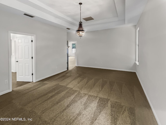 unfurnished room with a raised ceiling, visible vents, and baseboards