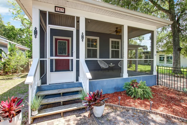 entrance to property with ceiling fan and fence