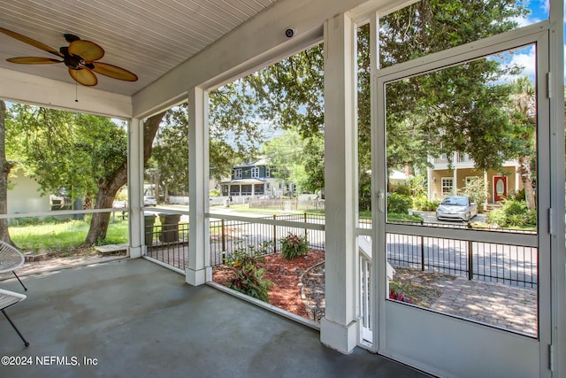 unfurnished sunroom featuring a ceiling fan