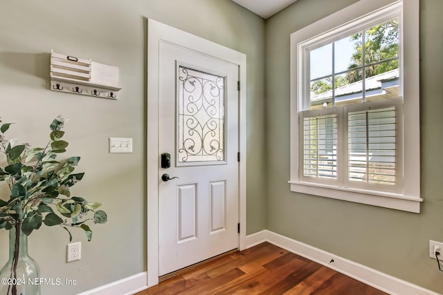 foyer entrance with dark wood-style floors and baseboards