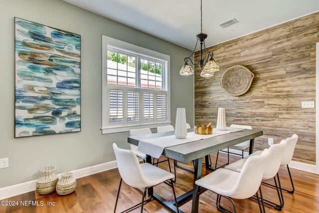 dining room featuring wood walls and hardwood / wood-style floors