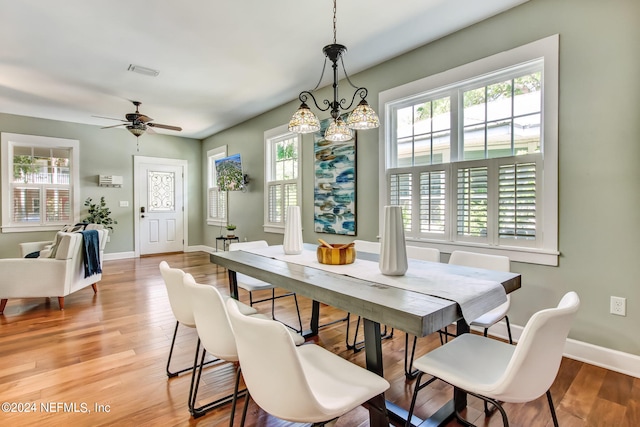 dining space featuring light wood finished floors, baseboards, visible vents, and a ceiling fan