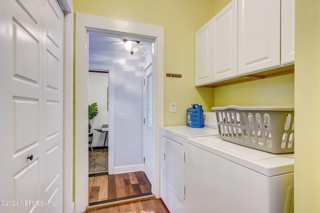 washroom with light wood finished floors, washer and clothes dryer, cabinet space, and baseboards