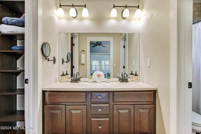 bathroom with toilet, vanity, and a shower with curtain