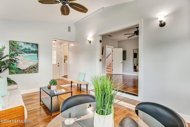 living room featuring ceiling fan, vaulted ceiling, and light hardwood / wood-style flooring