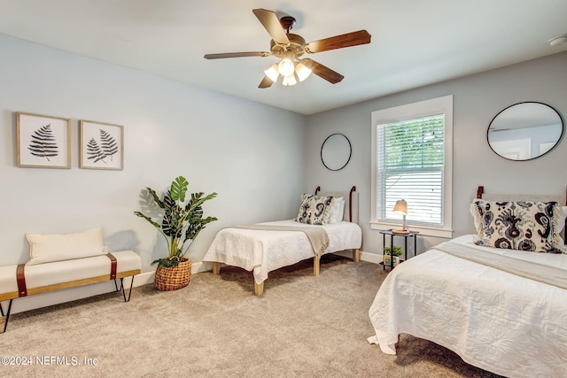 bedroom with light carpet, ceiling fan, and baseboards