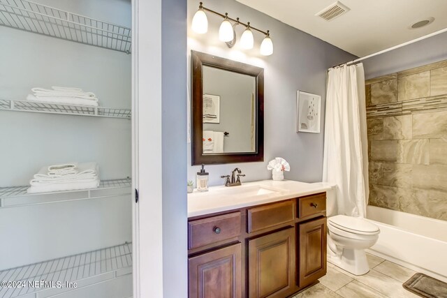 full bathroom with toilet, tile patterned flooring, shower / bath combo with shower curtain, and vanity