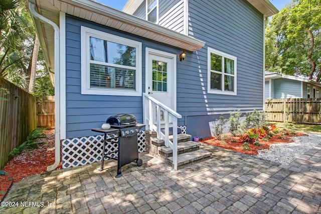 property entrance featuring a patio and fence