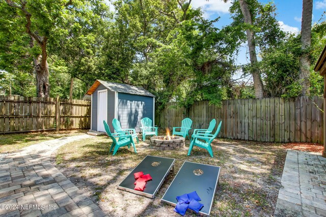 view of patio / terrace with a storage shed and a fire pit