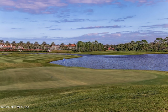 view of community with a yard, golf course view, and a water view