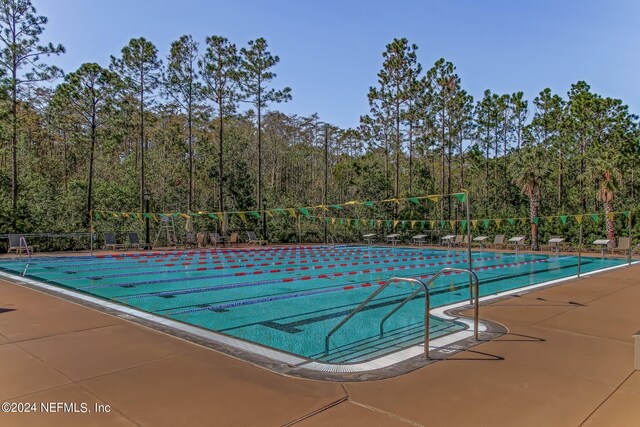 view of swimming pool featuring fence