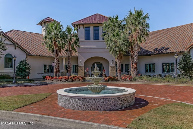 exterior space featuring a tiled roof and stucco siding