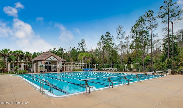 community pool featuring fence and a patio