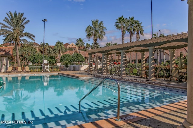 community pool featuring fence and a pergola