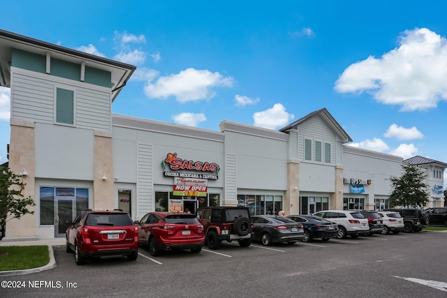 view of building exterior with uncovered parking