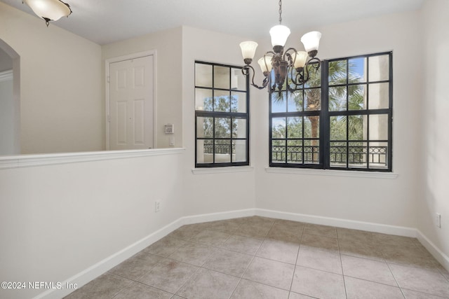 unfurnished dining area with light tile patterned floors and a notable chandelier