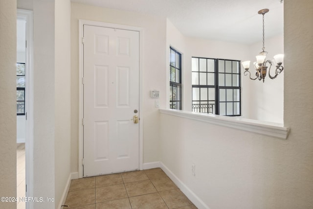 entryway featuring light tile patterned floors and a chandelier