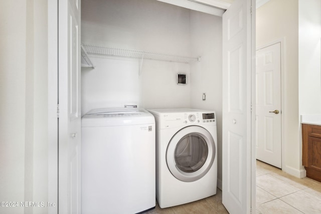 laundry room with light tile patterned floors, laundry area, and washer and clothes dryer