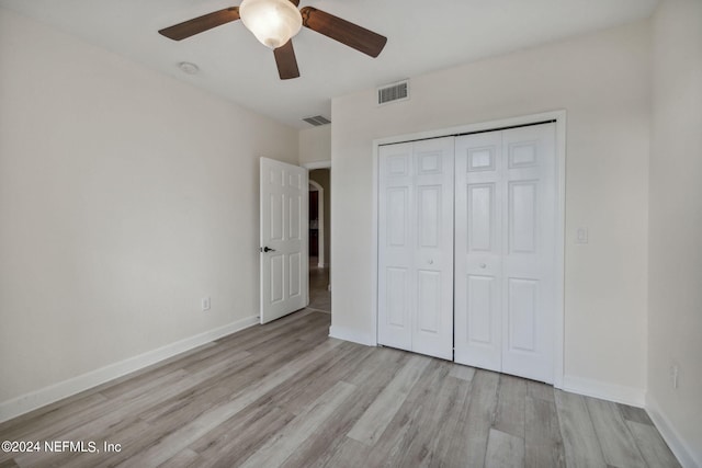 unfurnished bedroom featuring light hardwood / wood-style flooring, a closet, and ceiling fan