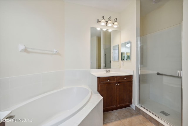 bathroom with a shower stall, tile patterned flooring, a bath, and vanity