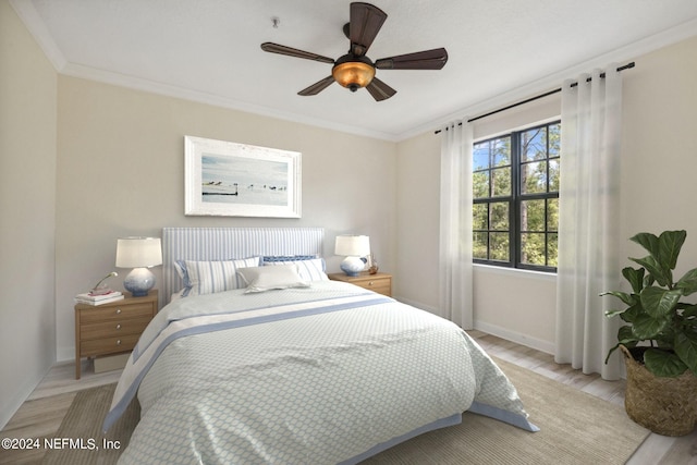 bedroom with light wood finished floors, baseboards, ornamental molding, and a ceiling fan