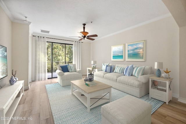 living room with visible vents, light wood-style floors, ornamental molding, ceiling fan, and baseboards