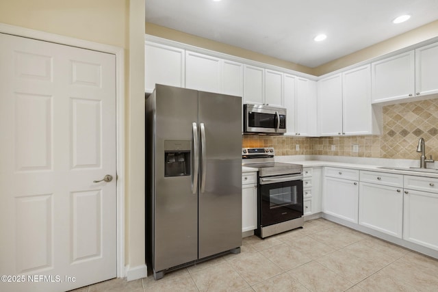 kitchen featuring a sink, white cabinets, stainless steel appliances, and light countertops