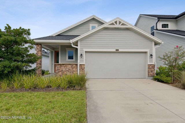 craftsman inspired home featuring a front lawn and a garage