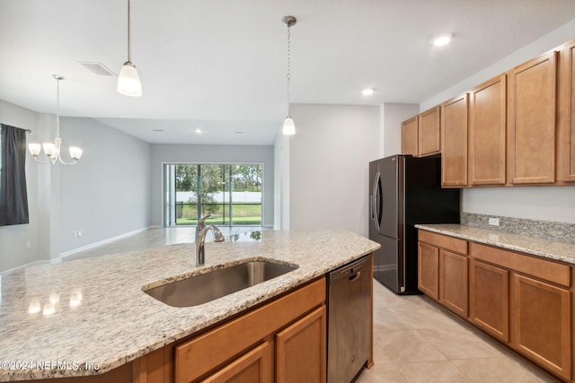 kitchen featuring dishwasher, freestanding refrigerator, light stone countertops, pendant lighting, and a sink