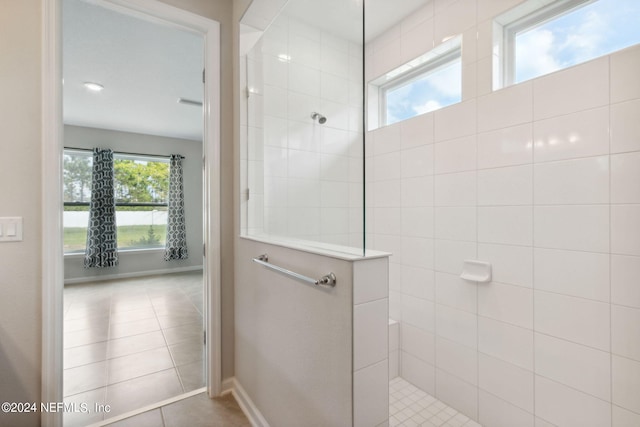 bathroom with tile patterned flooring, baseboards, and walk in shower