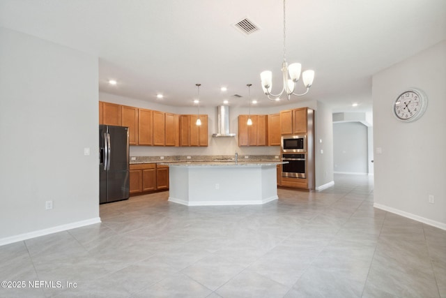 kitchen with stainless steel appliances, hanging light fixtures, a kitchen island with sink, a chandelier, and wall chimney exhaust hood